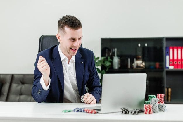 happy-businessman-wins-online-casino-while-playing-poker-office-workplace_97712-480