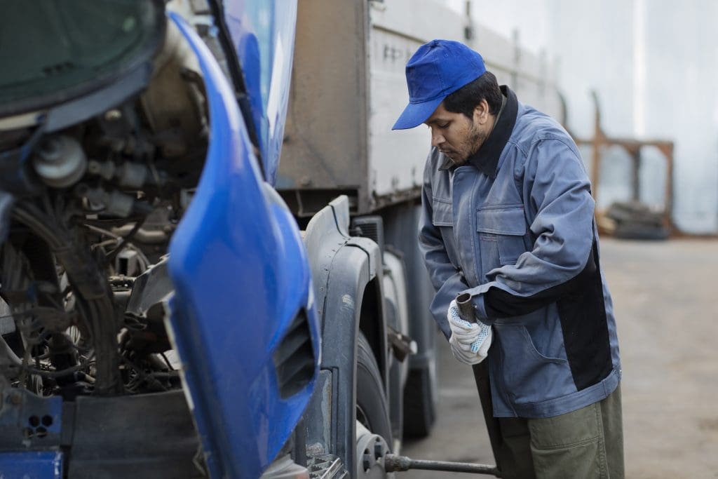 Full-shot-mechanic-checking-truck