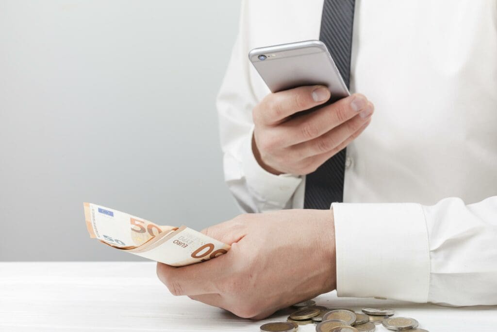 Man-holding-money-using-calculator